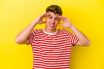 Fototapeta premium Young caucasian man isolated on yellow background receiving a pleasant surprise, excited and raising hands.