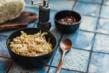 Salad with cabbage, eggs, corns and meat on the plate on rustic tiled table