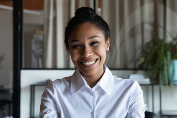 Headshot portrait of smiling African American young woman worker employee have webcam digital conference. Profile picture of happy biracial female talk speak on video call. Virtual event concept.