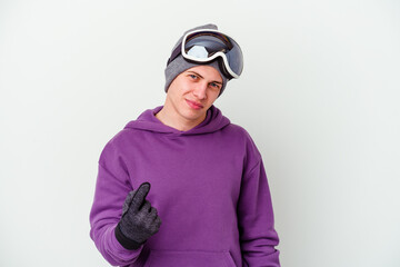 Young man holding a snowboard board isolated on white background pointing with finger at you as if inviting come closer.
