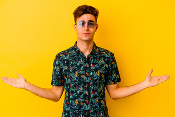 Young caucasian man wearing a Hawaiian shirt isolated on yellow background showing a welcome...