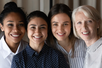 Close up headshot portrait of smiling multiethnic female colleagues coworkers look at camera pose in office. happy diverse multiracial women employees show unity. Success, leadership concept.