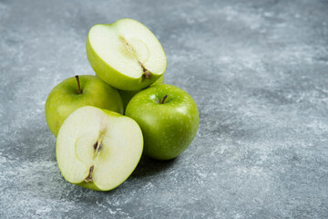 Three fresh whole and sliced apples on wooden piece