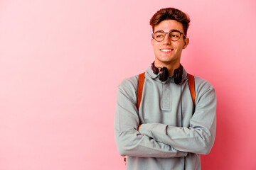 Young student man isolated on pink background smiling confident with crossed arms.