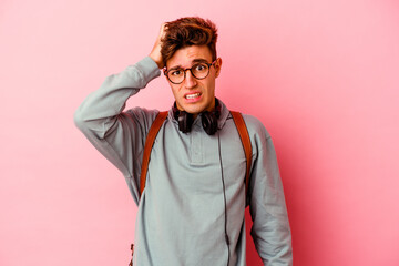 Young student man isolated on pink background being shocked, she has remembered important meeting.