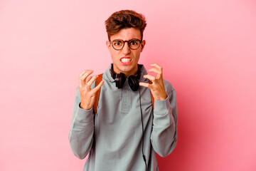 Young student man isolated on pink background upset screaming with tense hands.