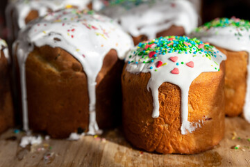 Many Traditional eastern europe Russian and ukrainian Easter cake kulich decorated with sweet sugar icing on wooden table morning sunlight ray. Tasty handmade christian orthodox holiday paska bread
