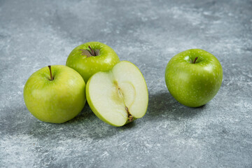 Three fresh whole and sliced apples on wooden piece
