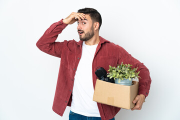 Young caucasian man making a move while picking up a box full of things isolated on white...