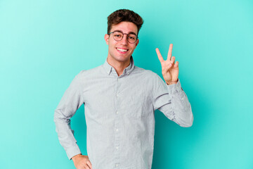 Young caucasian man isolated on blue background showing number two with fingers.