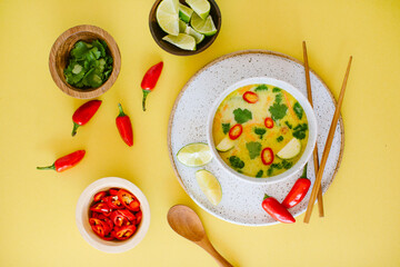 Overhead shot of spicy thai coconut soup with red chiles