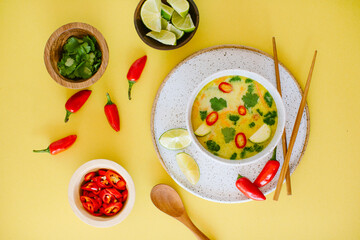 Overhead shot of spicy thai coconut soup with red chiles