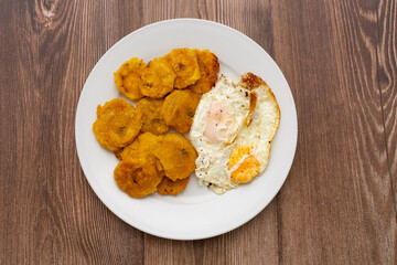 Plato de tostones con huevos fritos. Platillo de comida típica cubana y caribeña.