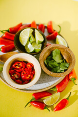 spicy chiles, cilantro, and lime on a plate as garnishes or toppings