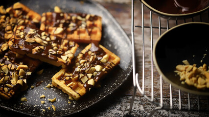 Selective focus. French waffles with chocolate and nuts. Making waffles