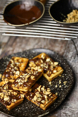 Selective focus. French waffles with chocolate and nuts. Making waffles