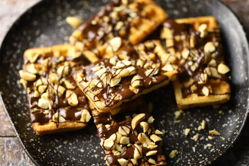 Selective focus. French waffles with chocolate and nuts. Making waffles