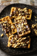 Selective focus. French waffles with chocolate and nuts. Making waffles