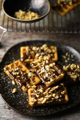 Selective focus. French waffles with chocolate and nuts. Making waffles