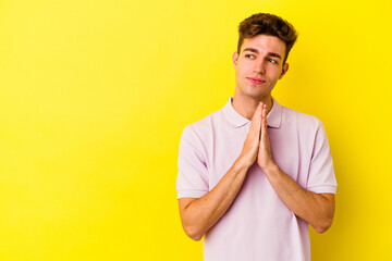 Young caucasian man isolated on yellow background making up plan in mind, setting up an idea.