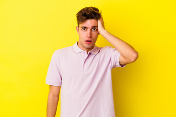 Young caucasian man isolated on yellow background being shocked, she has remembered important meeting.