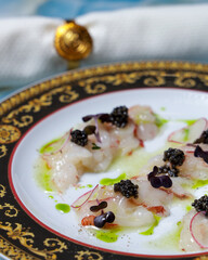 scallop dish in sauce with black caviar