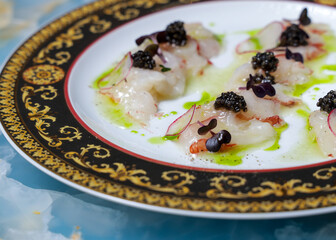scallop dish in sauce with black caviar