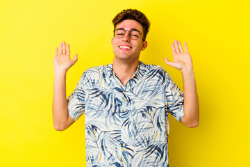 Young caucasian man isolated on yellow background joyful laughing a lot. Happiness concept.