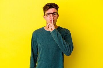 Young caucasian man isolated on yellow background keeping a secret or asking for silence.