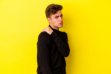 Young caucasian man isolated on yellow background having a shoulder pain.