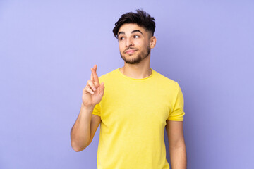 Arabian handsome man over isolated background with fingers crossing and wishing the best