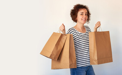 Happy young woman with shopping bags on white background