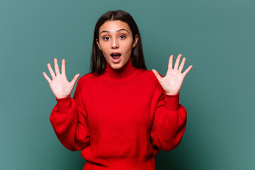 Young Indian woman isolated on blue background screaming to the sky, looking up, frustrated.