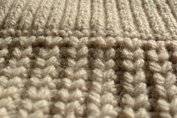 Close-up of a large knitted jumper. English knit and part of the collar. Beige, natural colour.