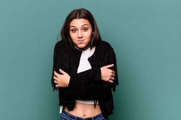 Young Indian woman isolated on blue background shrugs shoulders and open eyes confused.