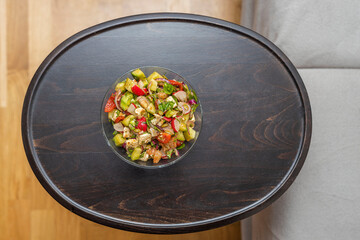 Close up view from above on salad bowl on coffee table. 