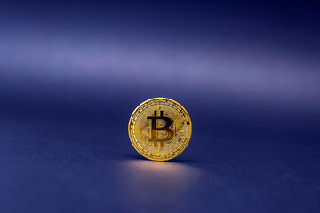 Bitcoin symbol in gold color on a blue background. The concept of crypto currencies as the future of the economy.