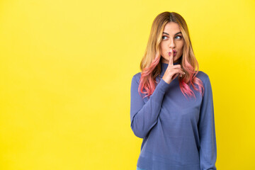 Young woman over isolated yellow background showing a sign of silence gesture putting finger in mouth