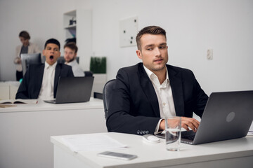 Two managers of a carsharing company are engaged in routine business in the office in a laptop....