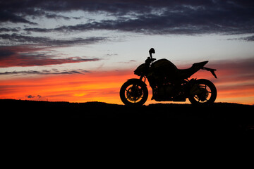 Motorbike parking with sunset background. Biker ride motorcycle. Silhouette of motobike. Trip and lifestyle motorbike Concept.