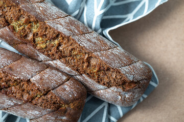 Garlic rye bread. Pastries with a fragrant garlic filling close-up. Two baguettes on a cardboard background with a gray napkin