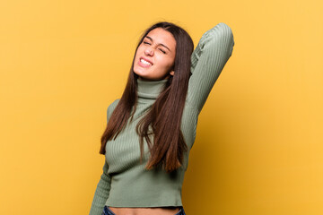 Fototapeta premium Young Indian woman isolated on yellow background suffering neck pain due to sedentary lifestyle.