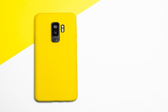 Modern Yellow Mobile Phone On A White And Yellow Background With A Copy Space