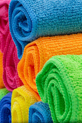 rolled towels in differnet colors such as yellow, orange, pink and blue for hotels, holiday, spa and hygiene as colorful background