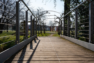 wooden bridge over the river and vineyard in the form of an arch. no people