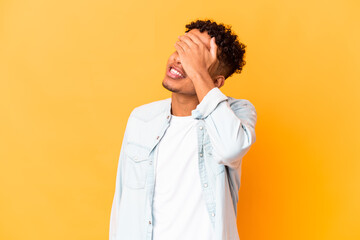 Young african american curly man isolated on purple laughs joyfully keeping hands on head. Happiness concept.