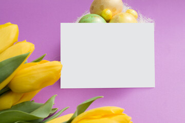 Blank card mock up with bouquet of yellow tulips and Easter nest with eggs