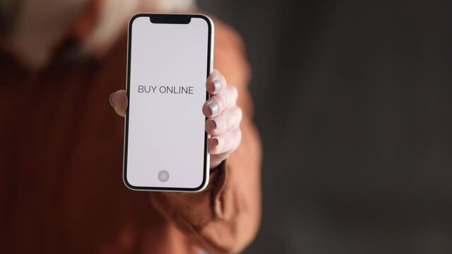 Wroclaw, Poland - 20 March 2021: woman holding iPhone 12 with text buy online  on screen