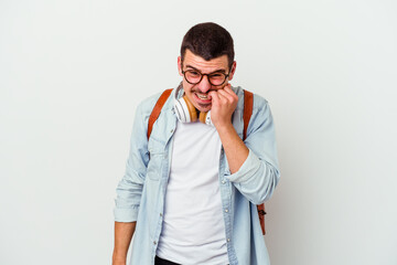 Young caucasian student man listening to music isolated on white background biting fingernails, nervous and very anxious.