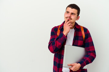 Young caucasian student man holding a laptop isolated on white background making up plan in mind,...